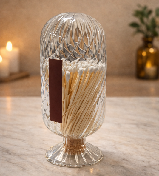 Clear glass container with matches on a wooden surface